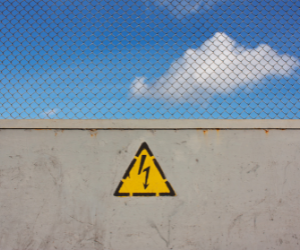 Brick wall with a caution sign to warn about paid call forwarding service